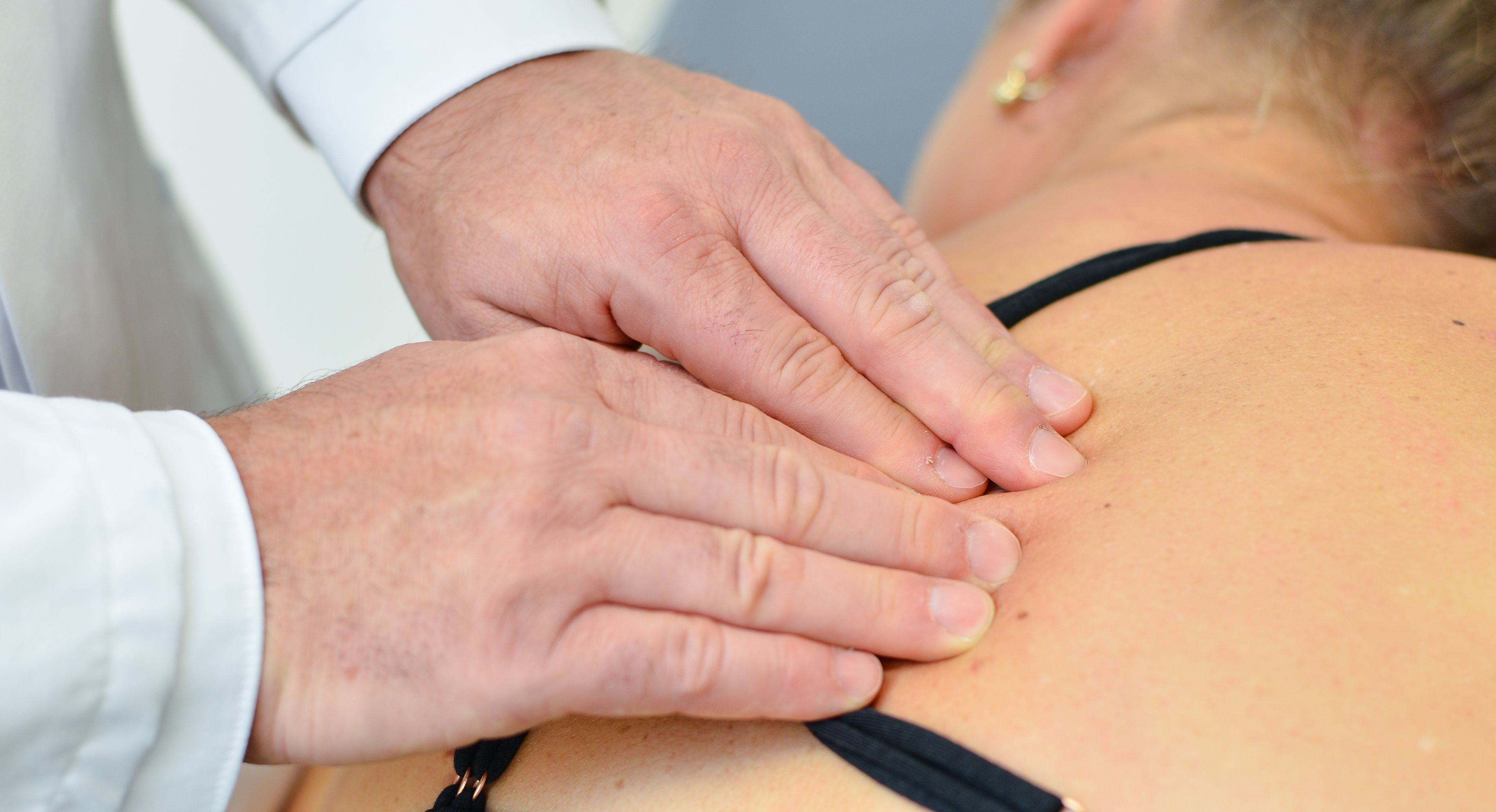 Arzt behandelt Patientin mit Schmerzen im Rücken